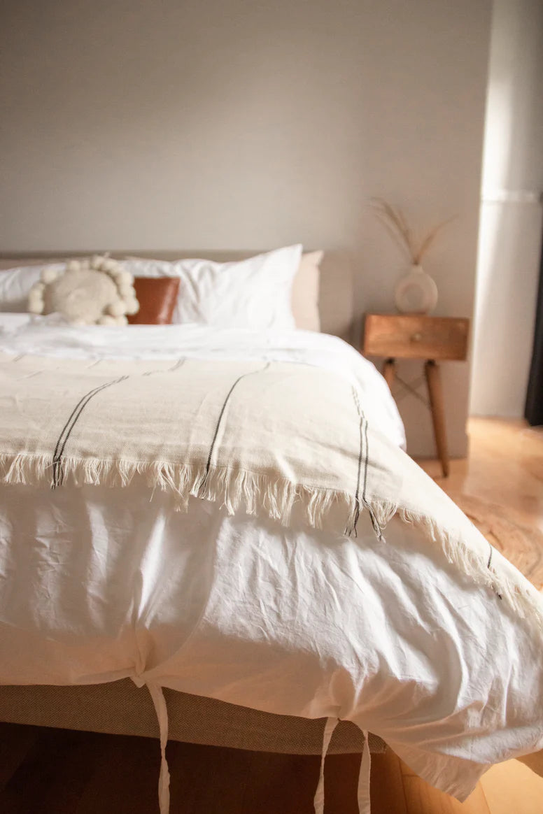 A bed room space with a bed made with eco-friendly organic linens that help promote a natural lifestyle.